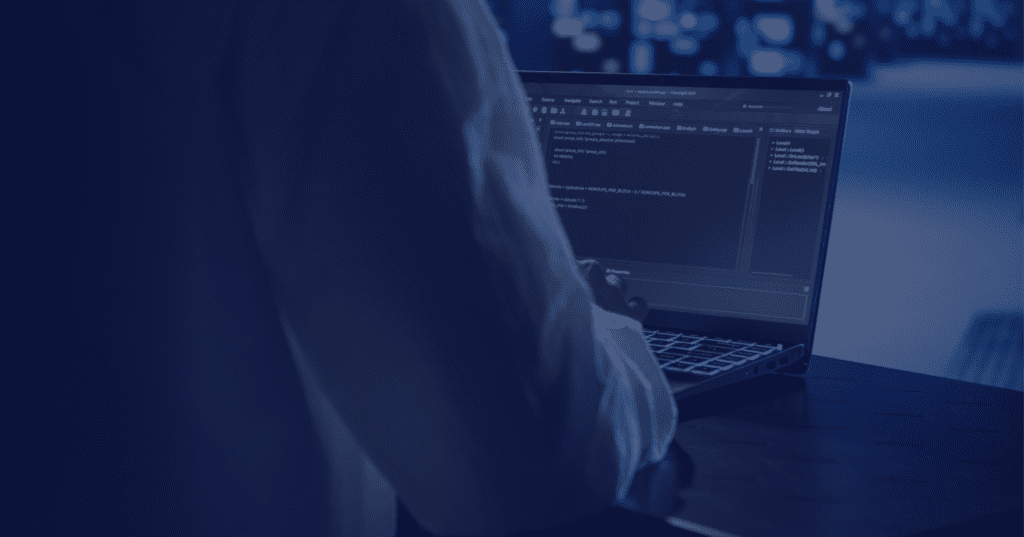 Developer working on code with laptop screen showing programming interface.