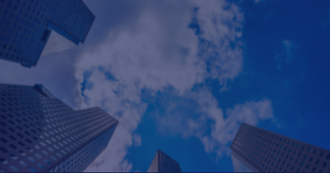 Corporate skyscrapers viewed from below against blue sky with clouds.