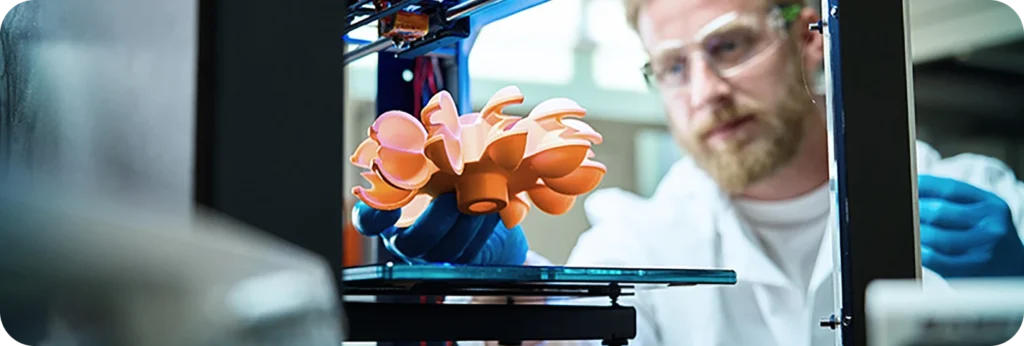 3D printing technology showing scientist in lab coat monitoring complex orange object being manufactured with additive manufacturing process