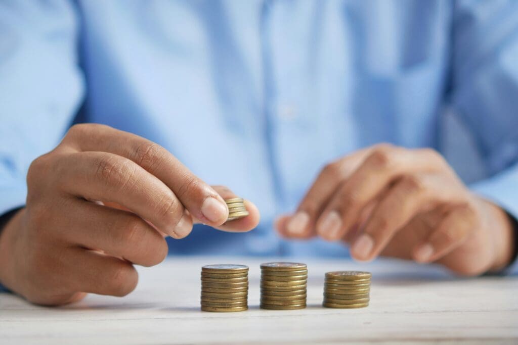 Business professional stacking coins showing investment growth financial planning and money management concept for wealth building strategies.