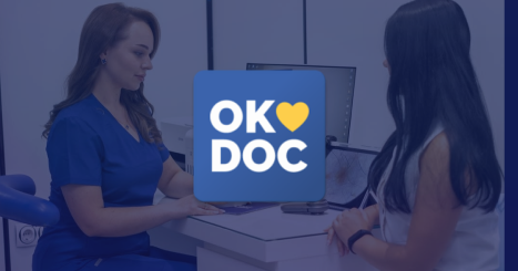 Female doctor discussing medical record with patient in clinic exam room, enhanced with the "OkDoc" logo