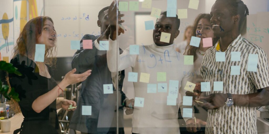 Team planning with sticky notes on a glass wall