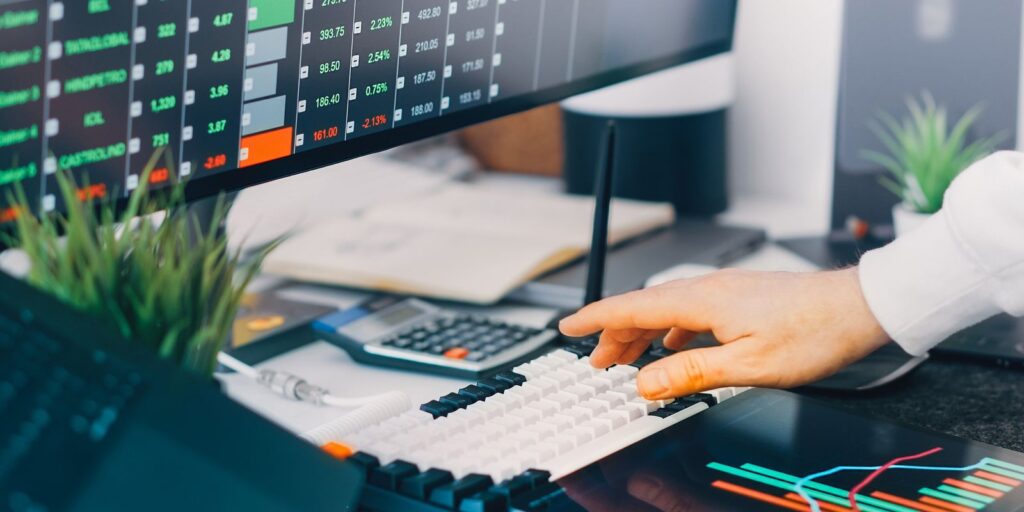 Analyst working across screens showing live market data