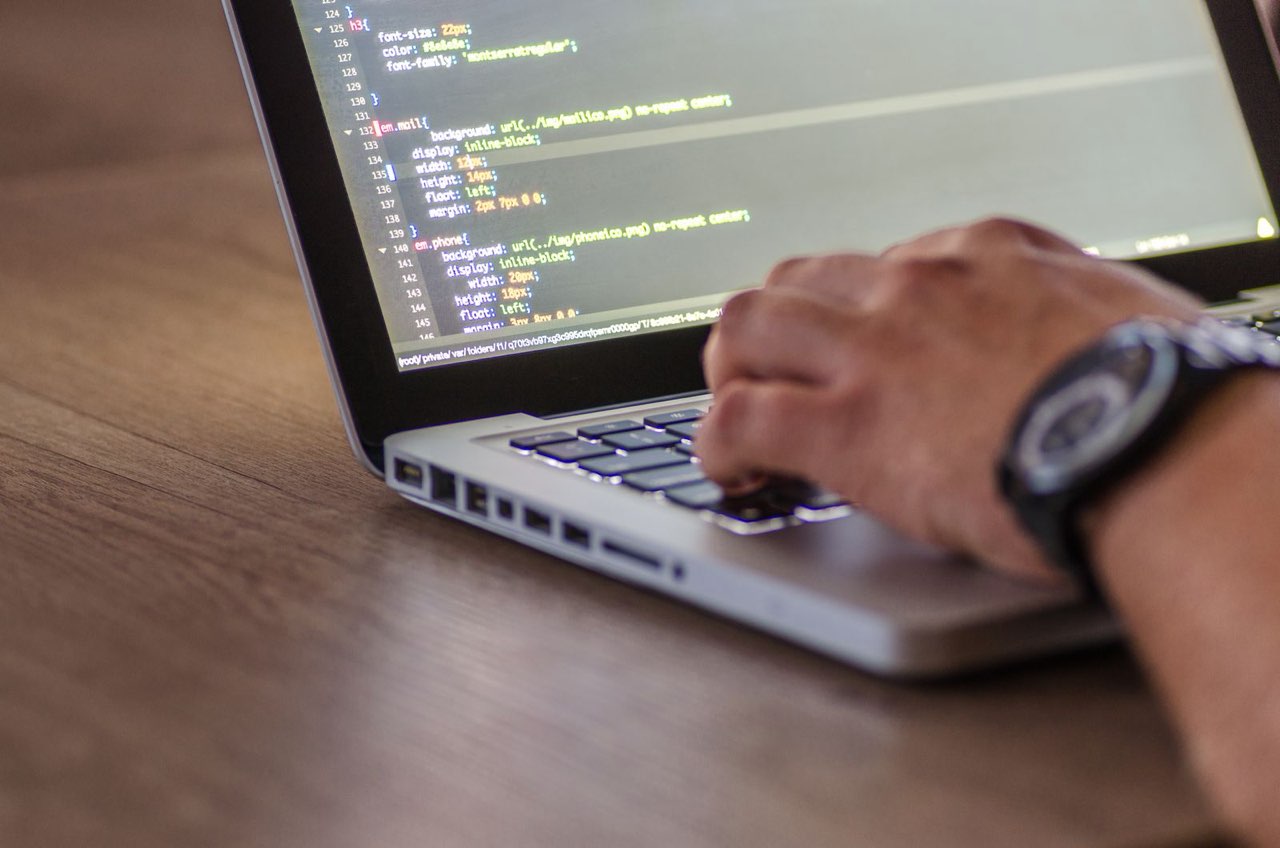 Engineer working on application code on a laptop