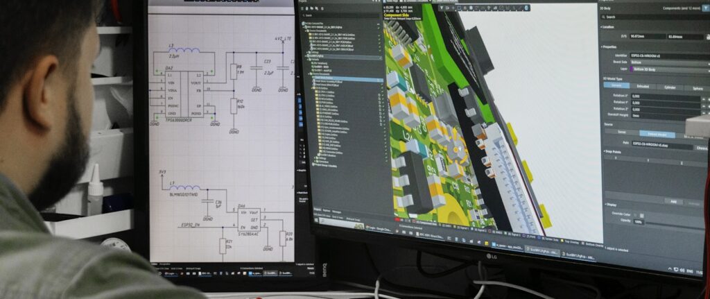 Engineer at a workstation reviewing dense circuit-board design software