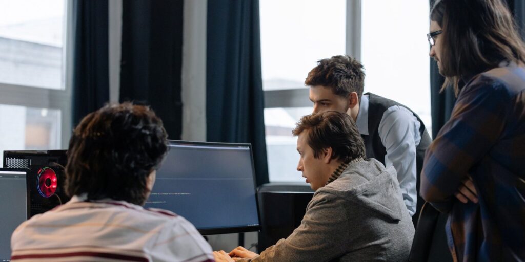 Team of engineers working together at a monitor