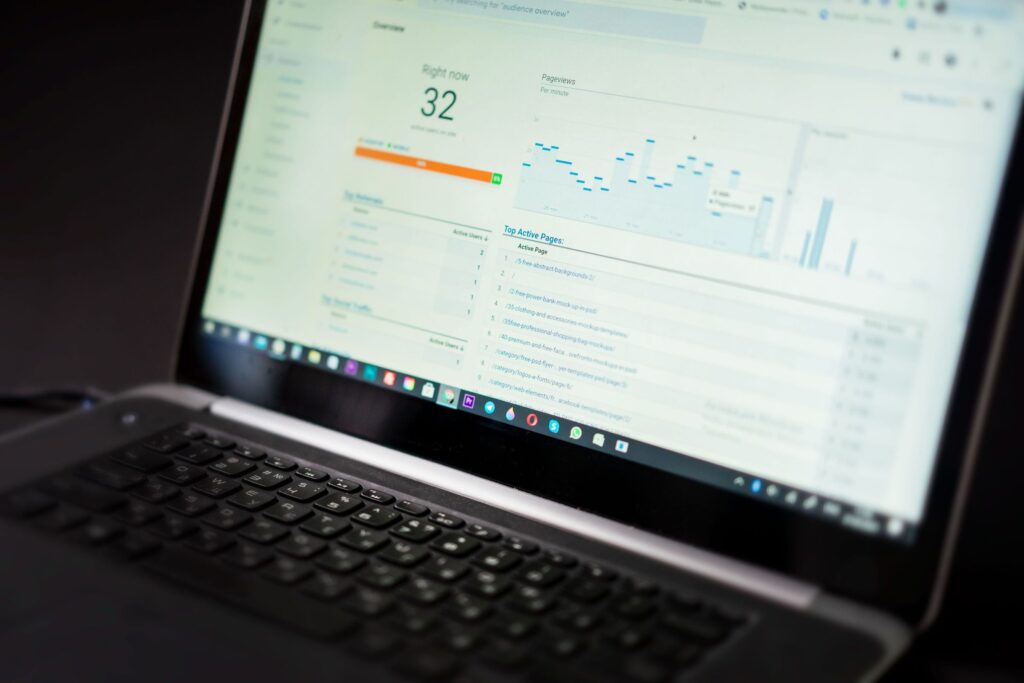 Laptop on a desk displaying an analytics dashboard with charts and a list of top pages (slightly blurred).