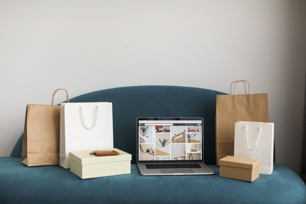 Laptop showing an online store surrounded by shopping bags