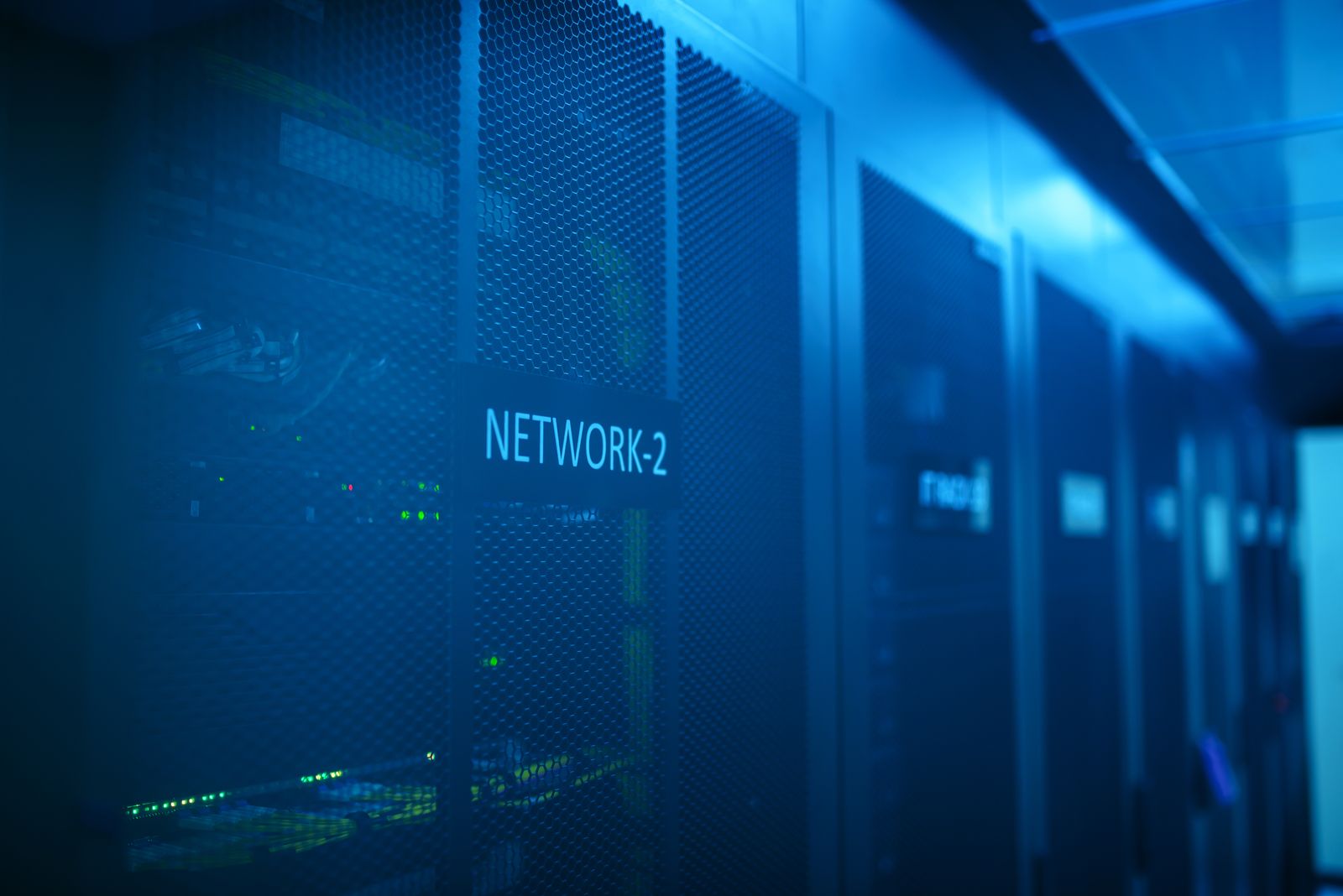 Server racks in a blue-lit data center aisle