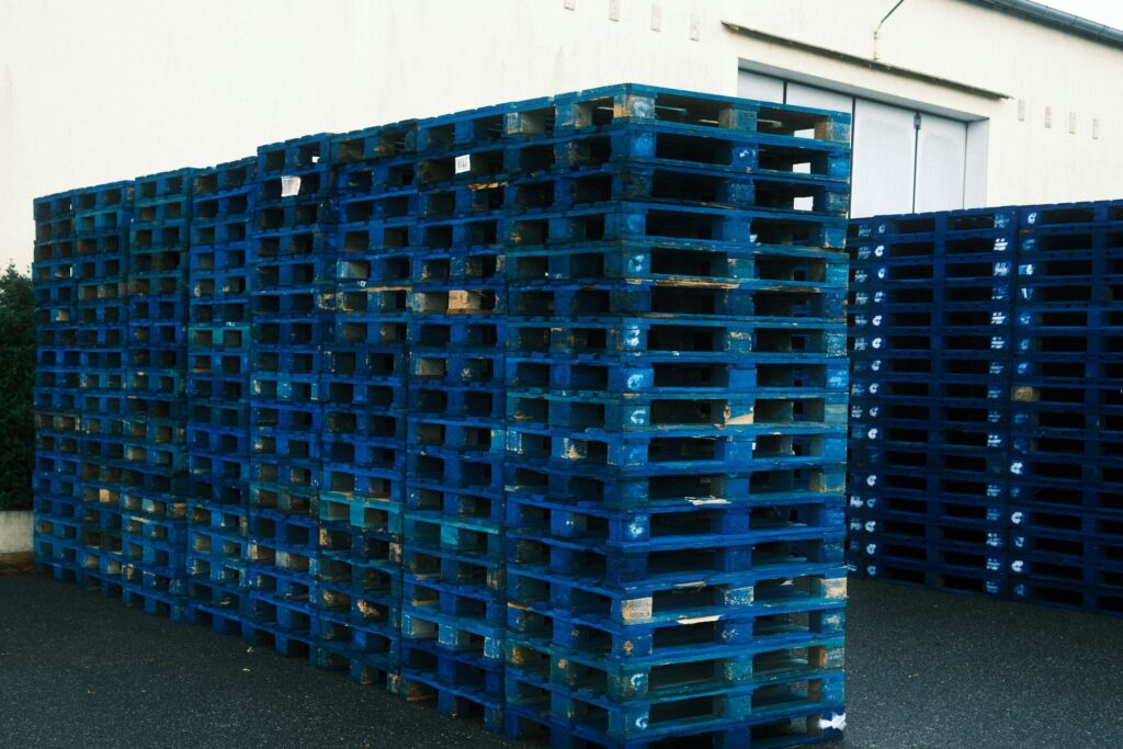 Stacks of blue shipping pallets outside a distribution warehouse